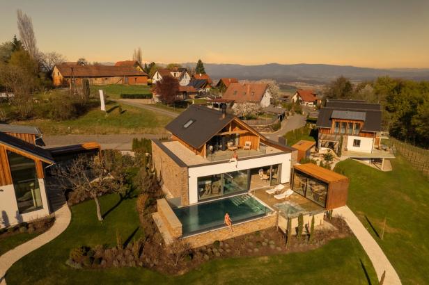Luftaufnahme eines modernen Hauses mit Pool und zwei Personen im Freien.