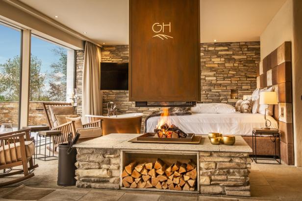 Ein luxuriöses Schlafzimmer mit Kamin und freistehender Badewanne.