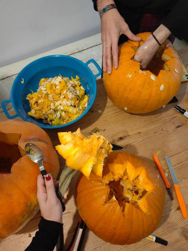 Personen schnitzen Kürbisse für Halloween.