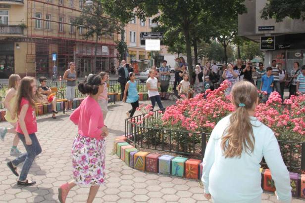 Eine Gruppe von Kindern spielt auf dem Friedrich-Hundwasser-Platz in Wien.