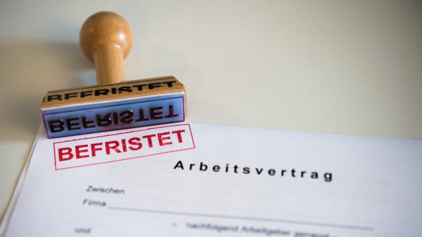 Ein Stempel mit dem Wort „befristet“ auf einem Arbeitsvertrag.