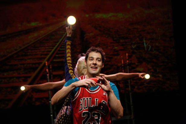 Ein Mann im Bulls-Trikot steht auf einer Bühne mit mehreren Personen und Lichtern.