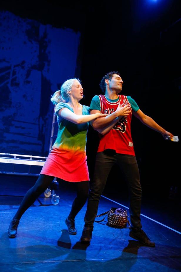 Zwei Schauspieler stehen auf einer Bühne und spielen eine Szene.