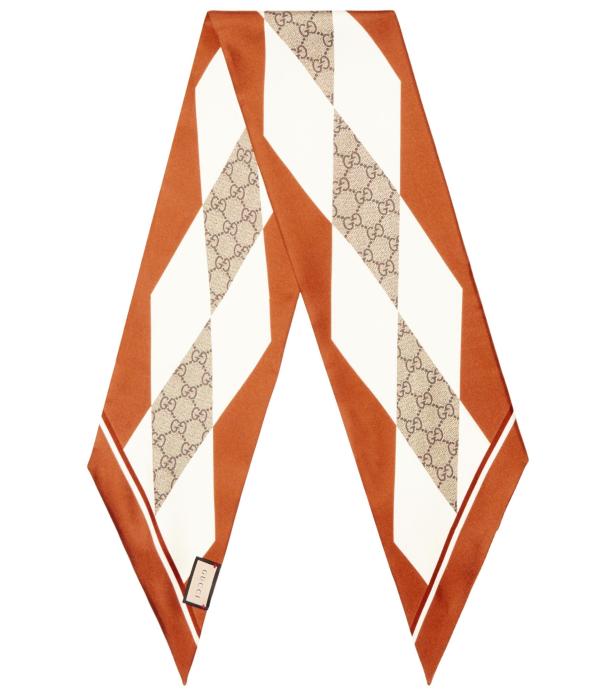 Ein orangefarbenes Gucci-Seidentuch mit geometrischem Muster und dem GG-Logo.