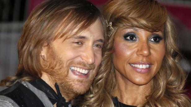 David Guetta und Cathy Guetta posieren lächelnd für ein Foto.