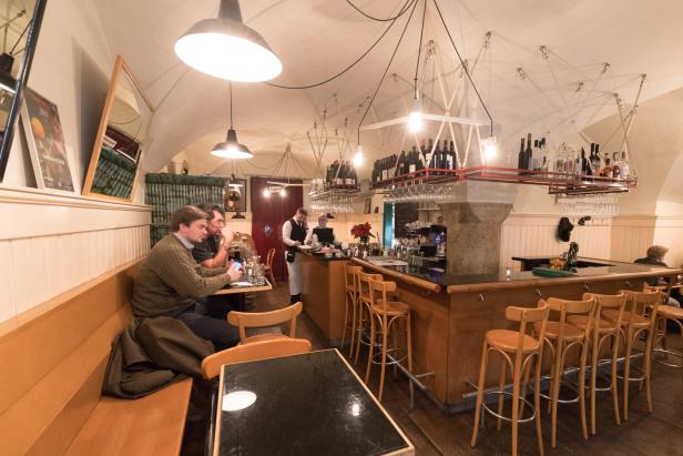 Gäste sitzen im Gasthaus Pöschl an der Bar und an Tischen.