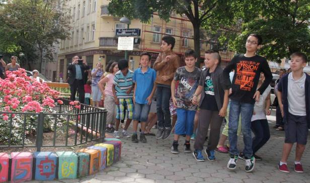 Eine Gruppe Kinder springt auf einem Platz in der Nähe des Friedensreich-Hundertwasser-Platzes.
