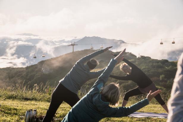 Eine Gruppe von Frauen macht Yoga in den Bergen.