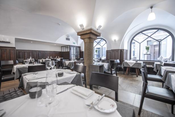 Ein gedeckter Tisch in einem eleganten Restaurant mit Gewölbedecke.