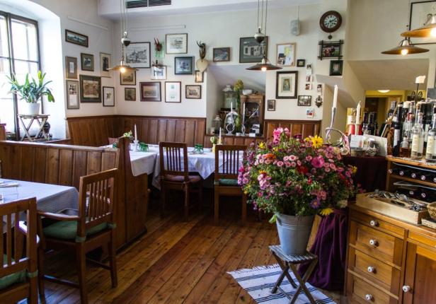 Innenansicht eines traditionellen Restaurants mit Holzboden und vielen Bildern an der Wand.