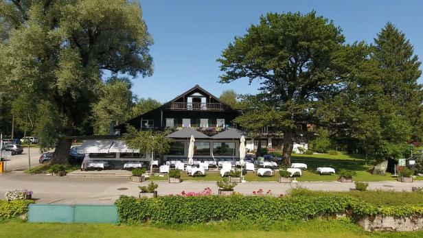 Ein Restaurant mit Tischen im Freien an einem sonnigen Tag.