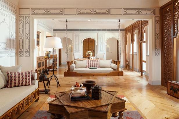 Das Wohnzimmer der Rani Rajkumari Suite mit einer Schaukelcouch und einem sternförmigen Tisch.