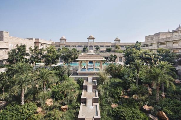 Der Rani Bagh Garten mit einem Pavillon und einem Pool vor einem Hotelgebäude.