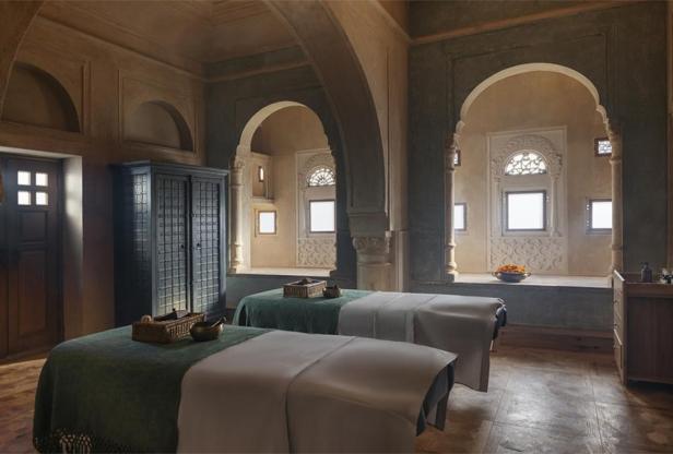 Zwei Massageliegen in einem luxuriösen Spa-Raum mit arabischer Architektur.