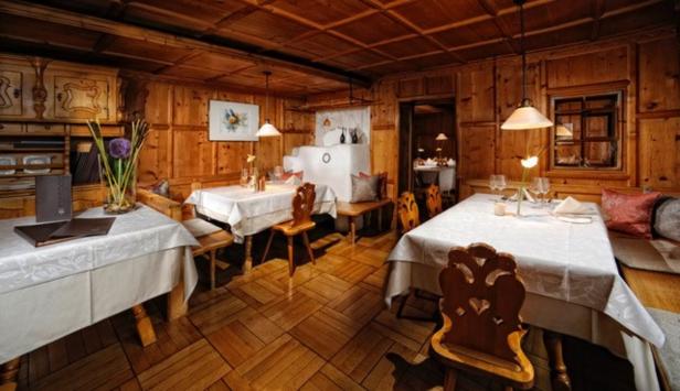 Ein Speisesaal im Restaurant Mangold mit Holztäfelung und gedeckten Tischen.