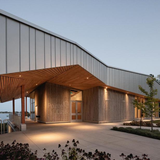 Das moderne Gebäude mit Holzverkleidung hat einen einladenden Eingangsbereich.