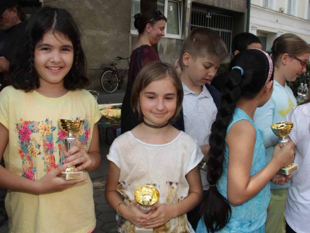 Eine Gruppe von Kindern hält Trophäen in den Händen.