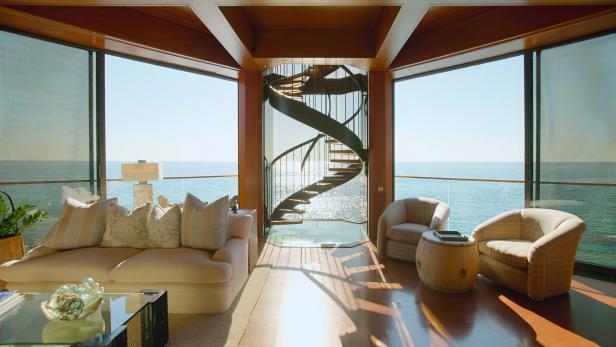 Ein Wohnzimmer mit Meerblick und einer Wendeltreppe in der Mitte.