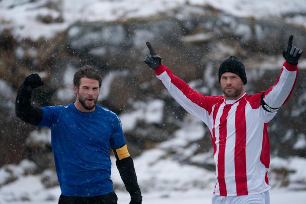 Zwei Fußballspieler jubeln im Schnee.