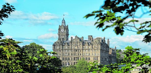 Das Balmoral Hotel in Edinburgh, Schottland, gesehen durch grüne Blätter.