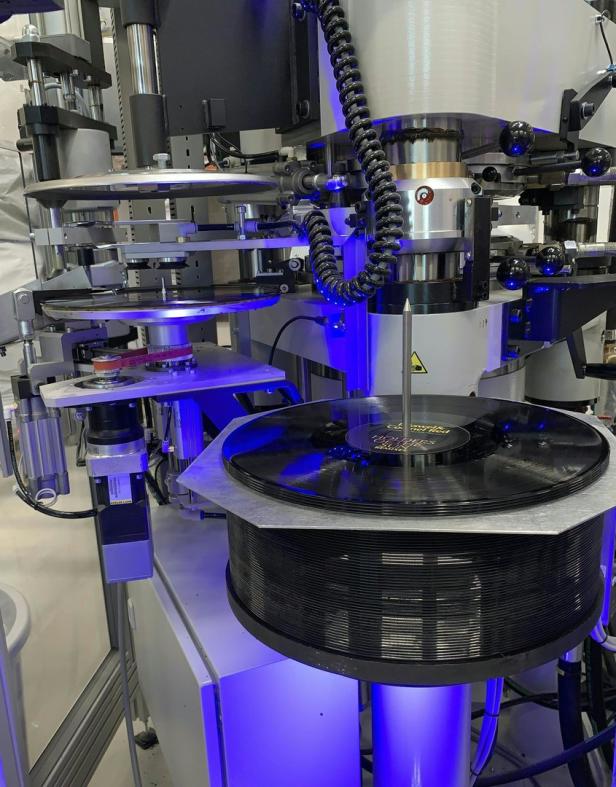 Eine Maschine produziert Schallplatten in einer Fabrik.