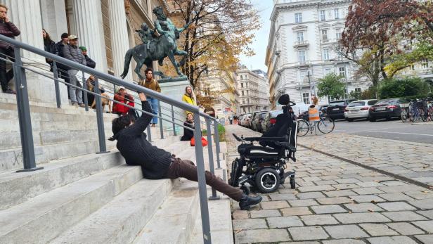 Protest vor Wiener Uni: Rollstuhlfahrer zieht sich am Geländer hoch