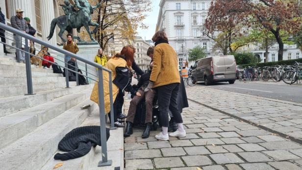 Protest vor Wiener Uni: Rollstuhlfahrer zieht sich am Geländer hoch