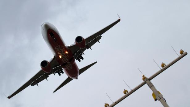 Ein Flugzeug von Air Berlin im Landeanflug vor bewölktem Himmel.