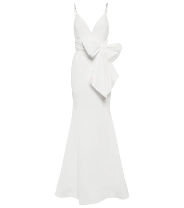Ein langes, weißes Kleid mit einem großen Schleifendetail an der Taille.