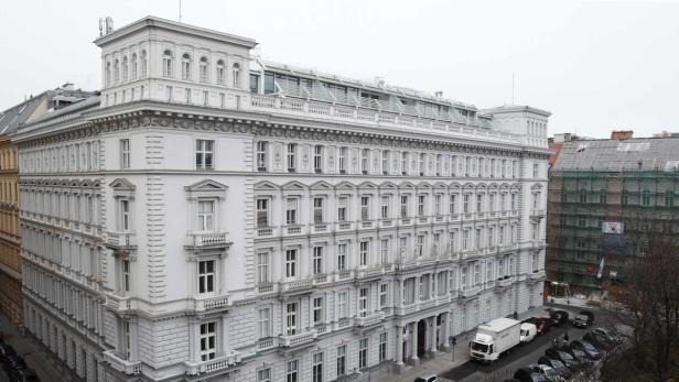 Ein großes, weißes Gebäude mit vielen Fenstern in einer Stadt.