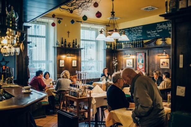 Gäste sitzen an Tischen in einem traditionellen deutschen Restaurant.