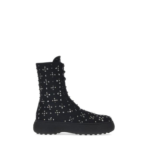 Ein schwarzer Schnürstiefel mit silbernen Pailletten auf einer dicken Sohle.