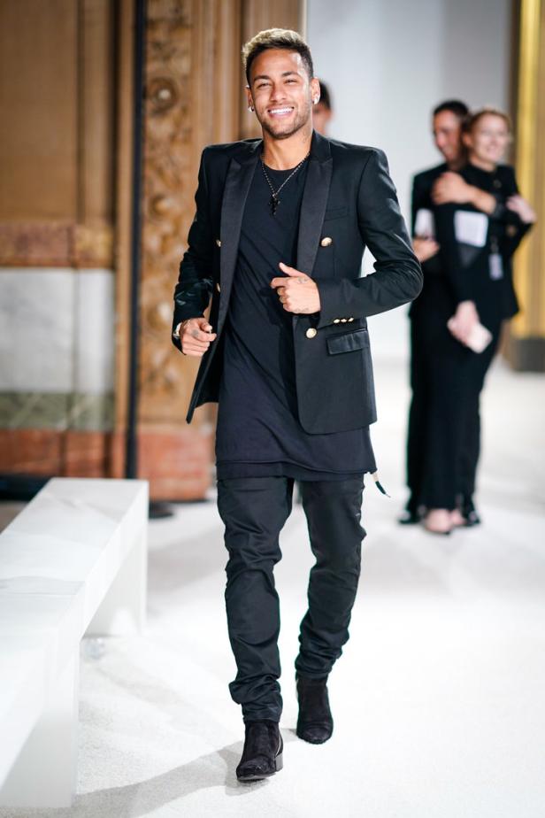 Neymar läuft in einem schwarzen Anzug auf einem Laufsteg.