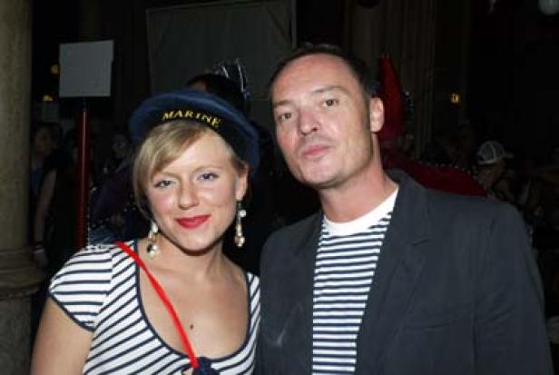 Eine Frau mit Matrosenmütze und ein Mann mit gestreiftem Hemd posieren für ein Foto.