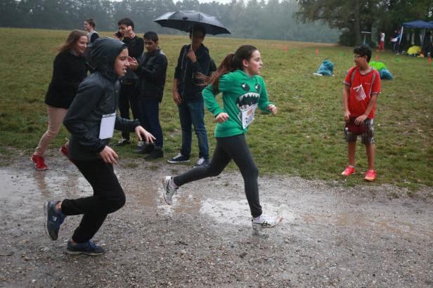 Zwei Kinder rennen bei Regenwetter ein Crossrennen.