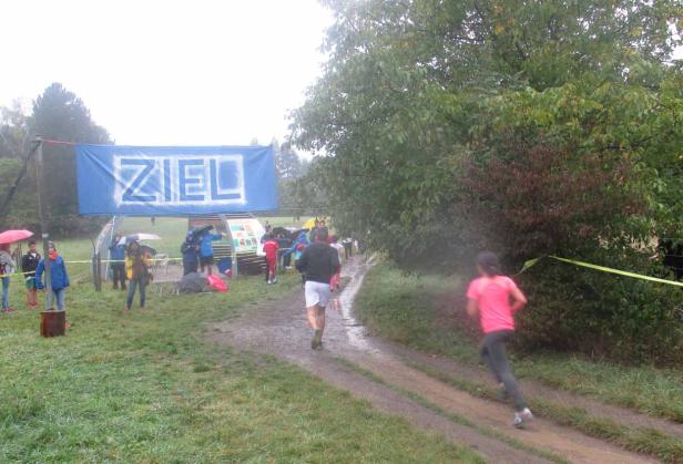 Ein Läufer überquert die Ziellinie bei einem Rennen im Regen.