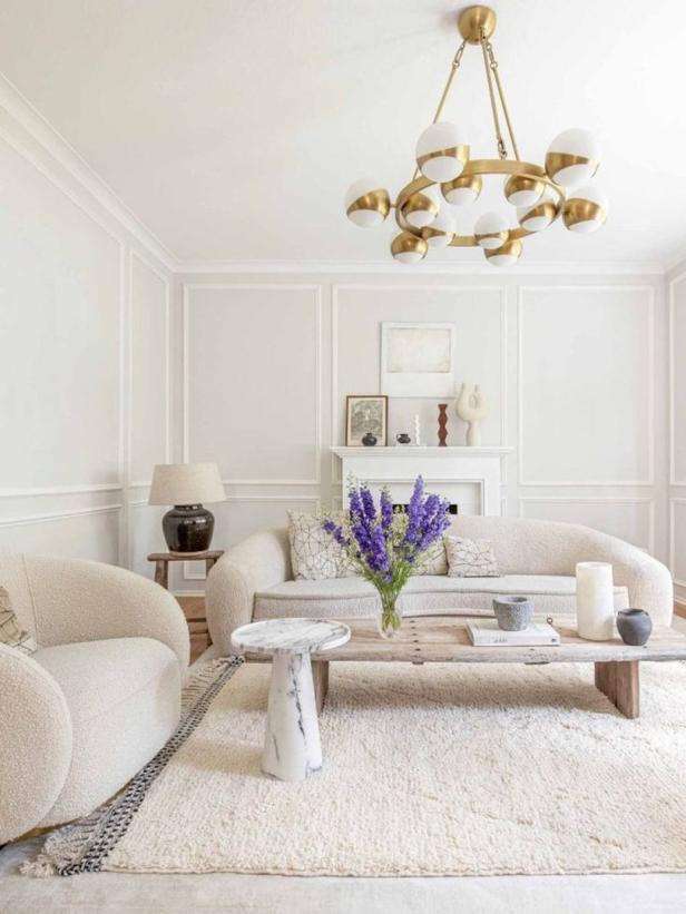 Ein Wohnzimmer in neutralen Farben mit einem Sofa, einem Sessel und einem Couchtisch.