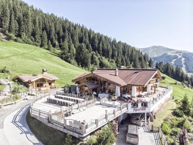 Das Restaurant Rösslalm liegt in einer grünen Berglandschaft.