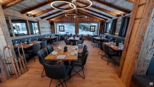 Einladendes Restaurant im Chalet-Stil mit Blick auf eine verschneite Landschaft.