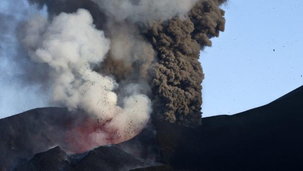Ein Vulkan bricht aus und speit Rauch und Lava in den Himmel.