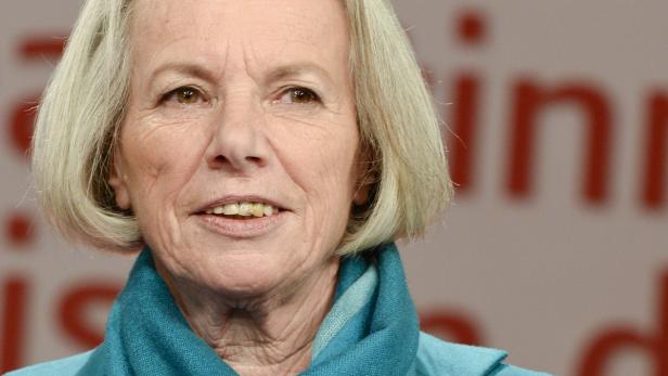 Nahaufnahme einer Frau mit blonden Haaren und einem türkisfarbenen Schal.