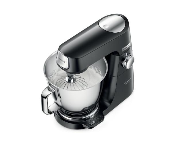 Eine schwarze Kenwood Küchenmaschine mit Schneebesen und einer Schüssel mit steif geschlagener Sahne.