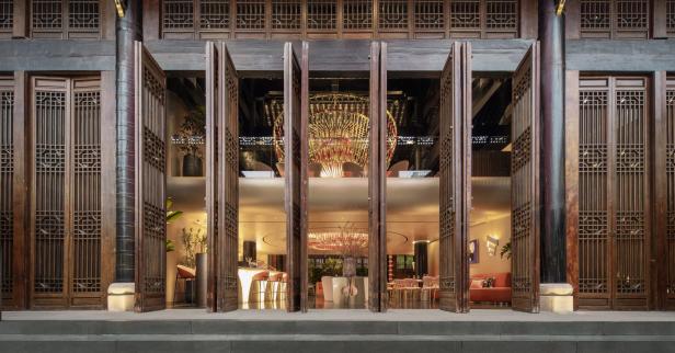 Der Blick durch geöffnete Holztüren auf das Interieur eines eleganten Restaurants.