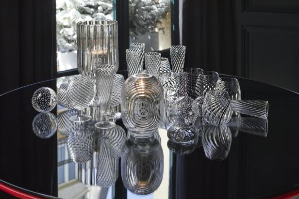 Eine Sammlung von dekorativen Glasobjekten auf einem glänzenden Tisch.