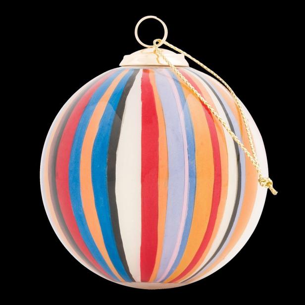 Eine bunte Weihnachtskugel mit vertikalen Streifen hängt an einer goldenen Schnur.