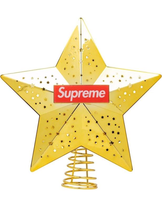 Ein goldener Baumschmuckstern mit dem „Supreme“-Logo.