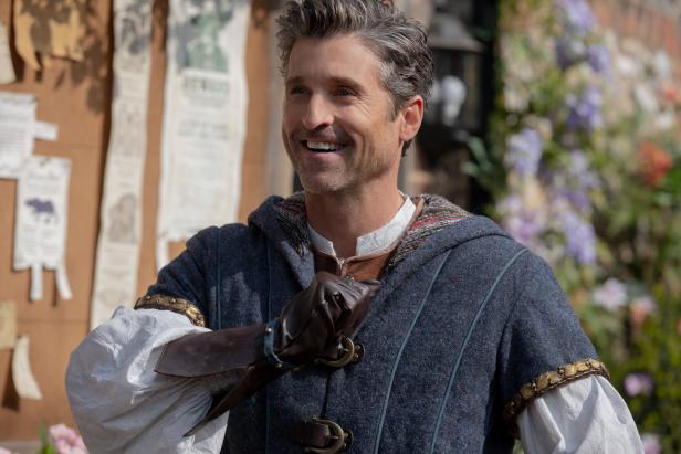Patrick Dempsey in mittelalterlicher Kleidung lächelt.