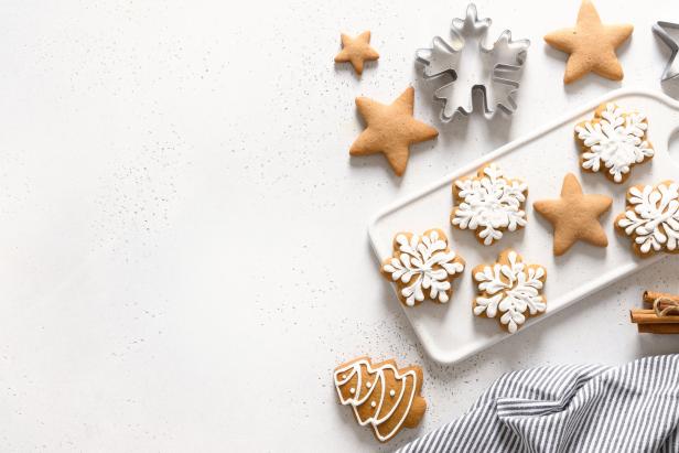 Weihnachtsplätzchen in Stern- und Schneeflockenform liegen auf einem Tisch.