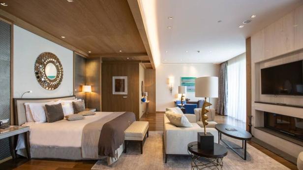 Ein luxuriöses Hotelzimmer mit einem großen Bett und einem Wohnbereich.