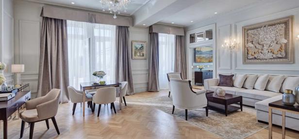 Ein elegantes Wohnzimmer mit hellen Möbeln und einem Parkettboden.